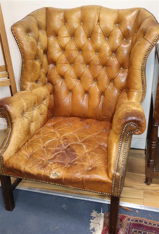A pair of leather tan wing armchairs
